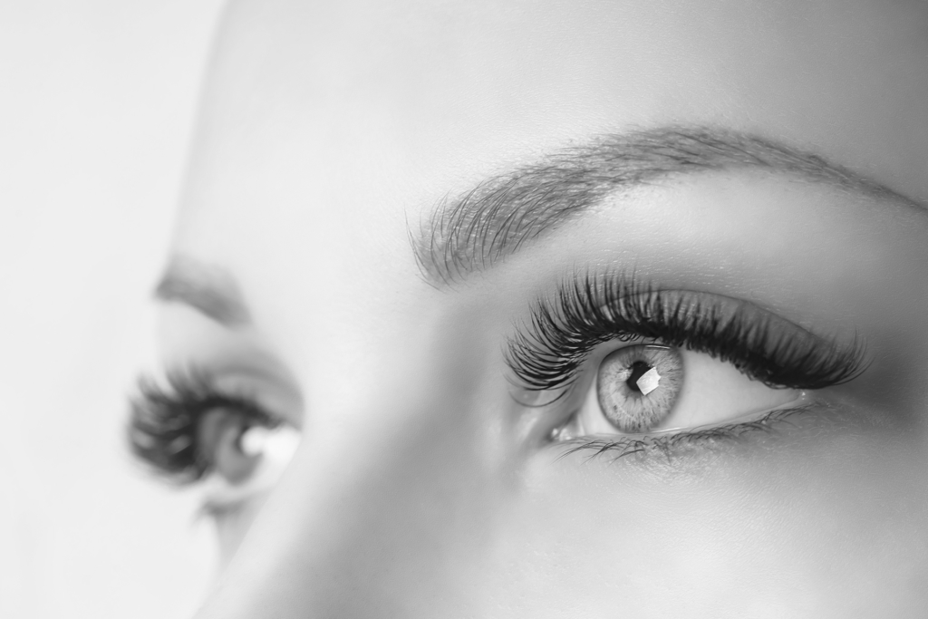 Long April Tag Eyelash Extension Procedure. Woman Eye with Long Eyelashes. Close up ...